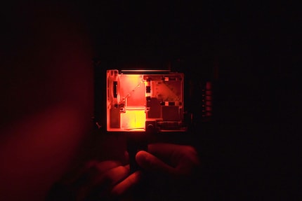 If I illuminate with red light, where the blue laser module would normally be, the red won't reach the lens, because the dichroic mirror only reflects the blue spectral components.