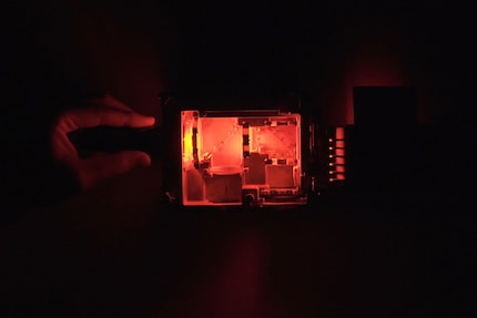 In contrast to blue, red passes through both mirrors to the lens.