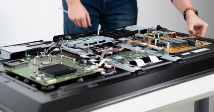 Four circuit boards: the orange one is the power supply. The large green circuit board is home to two TV processors.