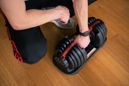 To adjust the weight, you need to briefly place the dumbbell in the holder. A dumbbell stand is available separately.