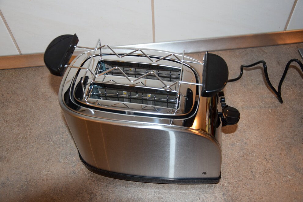 Mit im Lieferumfang dabei ist ein abnehmbarer Brötchenaufsatz. Dieser liegt bei Benutzung locker auf dem Toaster auf.