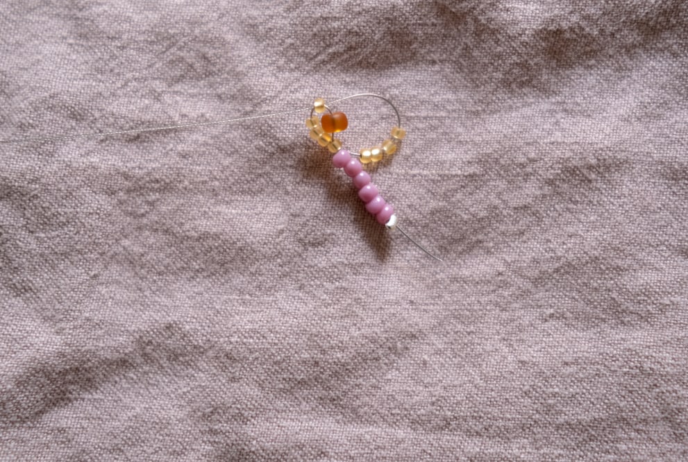 Der Blumenkranz sollte sich lückenlos um die mittlere Perle bilden.