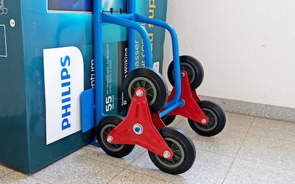 Auspacken, Räder und Unterlagsscheibe über Aufhängung ziehen und mit «Haarklammer» fixieren.