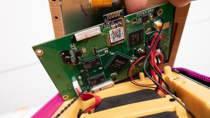 Ein Flachbandkabel und ein paar Schrauben müssen weg, um ans Display zu kommen.