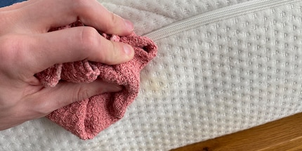 Mit dem Waschlappen massierst du die Verschmutzung aus der Matratzenhülle.