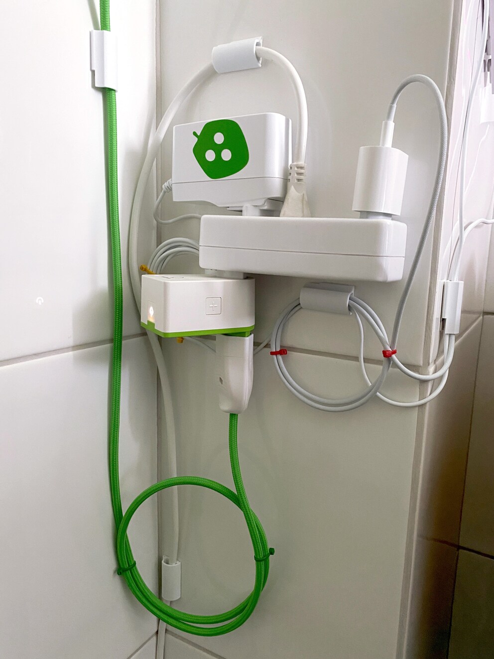 Der Teil, den man üblicherweise nicht sehen will – doch ist das nicht der Olymp der Ästhetik? Der grüne myStrom-Switch mit einem Kabel derselben sympathischen Berner Firma, dazu passend das Nanoleaf-Netzteil, dem ein grüner Sticker mit dem Firmenlogo beigelegt war. Beachte auch die 5 Kabelführungs-Clips!