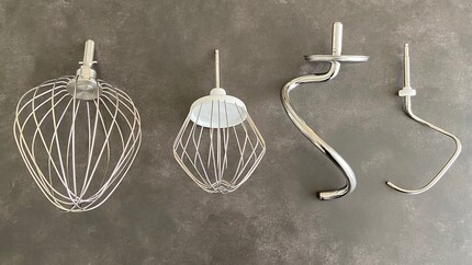 Der Ballonschneebesen und Knethaken meiner Bosch-Maschine (jeweils rechts) sind im direkten Vergleich Leichtgewichte: Der Knethaken von Kenwood wiegt mit 355 Gramm knapp siebenmal so viel wie der von Bosch (51 Gramm).