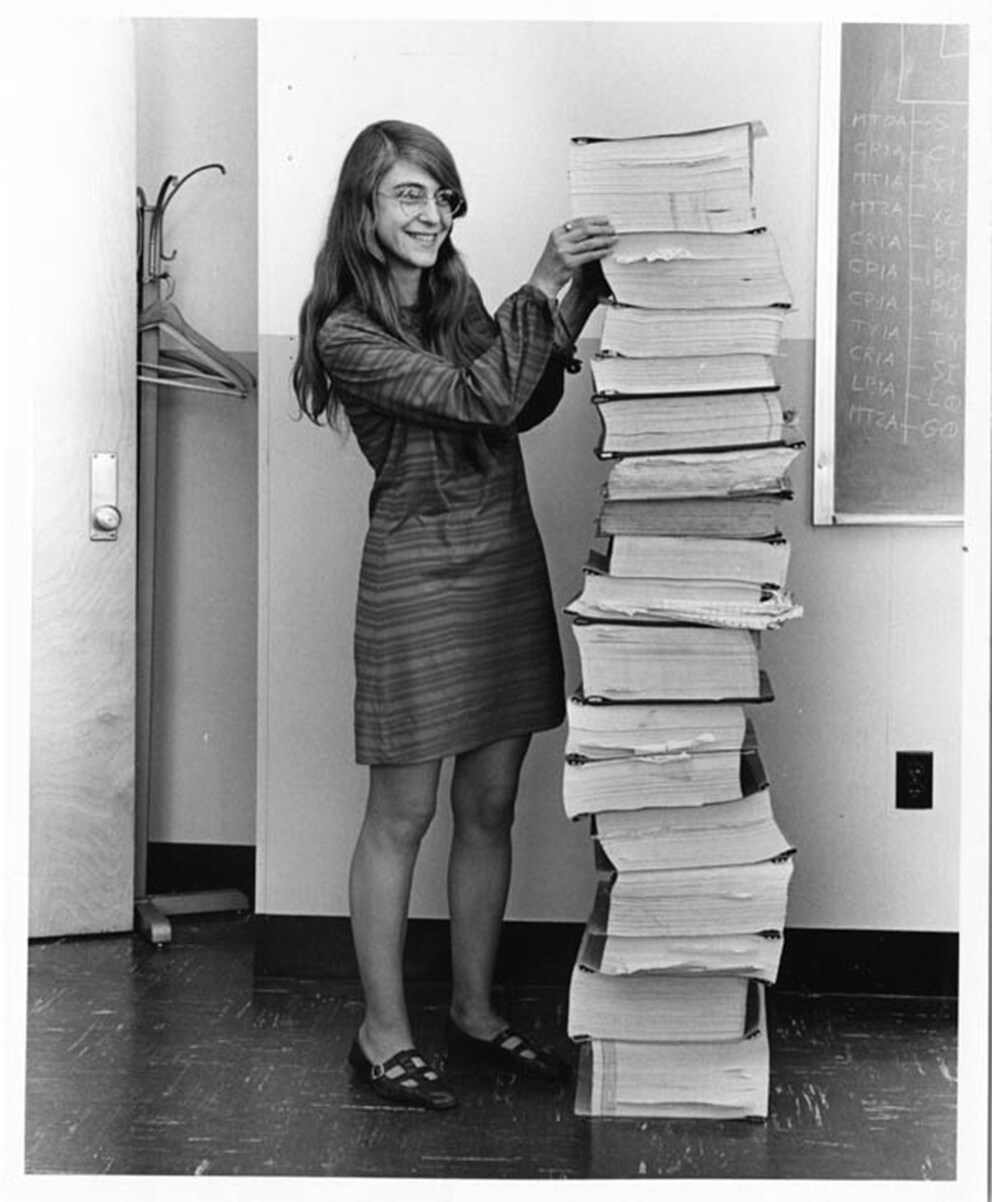 Margaret Hamilton neben dem Code, den sie geschrieben hat und der Neil Armstrong zum Mond gebracht hat