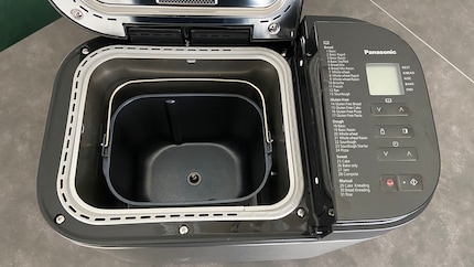 Im Inneren des Brotbackautomaten platzierst du die Backform. Den Knethaken auf den dafür vorgesehenen Befestigungsschaft (Mitte).
