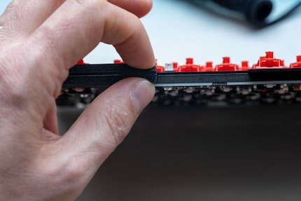 You can see the insulation mat between the cover plate and the circuit board. What I’m squeezing with my fingers here is the gaskets that give the keyboard its flexible typing feel.