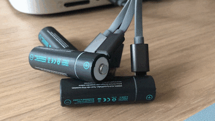 The USB to Micro USB-C cable in use: while charging, the batteries flash; once charged, the light changes to a solid green.