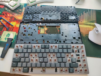 All three parts of the MX Mechanical Mini at a glance: the bottom part at the top, the middle part in the middle and the cover plate with switches and underlying circuit board at the bottom.