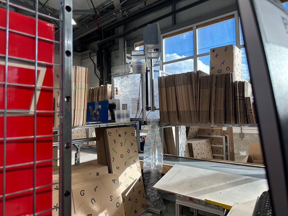 This is what a packaging station in Wohlen looks like. The machine high up in the centre fills the air pillows when needed, which saves space.