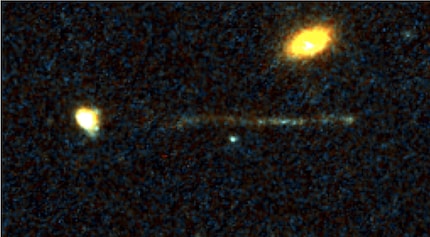 An escaped black hole | A narrow strip of young stars is located outside the galaxy. At the tip of the streak, scientists suspect an extremely massive black hole that has been ejected from the galaxy.