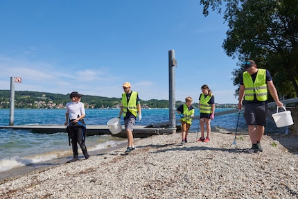 Helfer an Land behalten die Luftbläschen der Tauchteams im Auge und säubern das Ufer.