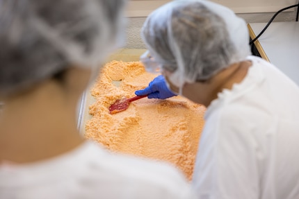 Sandra and Ursula evenly spread out the chilli salt on the tray so it can dry.
