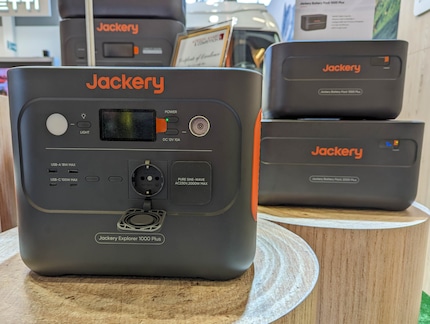 Jackery Explorer 1000 Plus mit Battey Packs im Hintergrund.