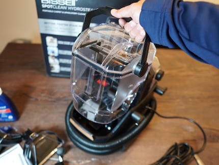 The handle also functions as a locking mechanism. Below, you can see the rolled-up hose.