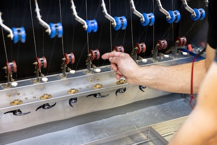 The cocoons are threaded by hand before a machine unravels them completely.