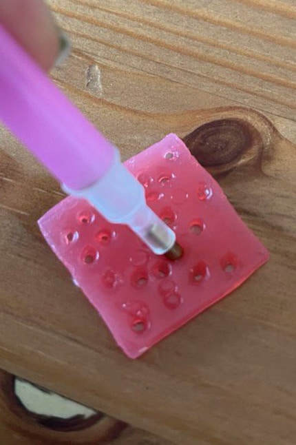 I press the applicator into the wax so that the diamonds stick to it.