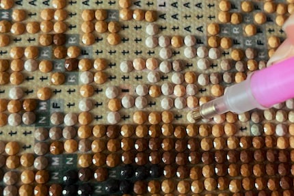 I use the applicator to place the diamonds in the right place on the symbol. 