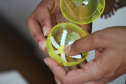 Steffi presses the flower into a capsule toy to shape it.