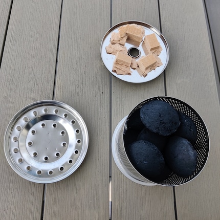 Der Feuerbehälter besteht aus der Anzündschale, dem Holzkohlebehälter sowie dem zugehörigen Deckel. Achte darauf, nicht zu viele Briketts in den Behälter zu füllen.