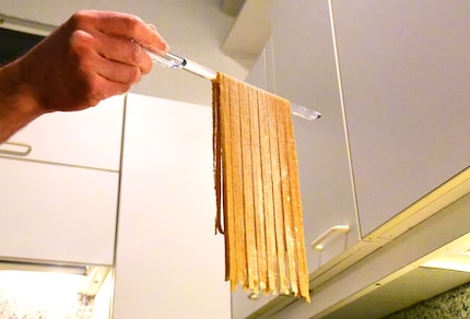 Die zurechtgeschnittenen und aufgefangenen Fettuccine können...