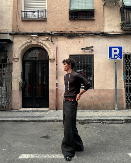 A dark brown top with black pants, a red belt with black shoes – this outfit’s all about breaking the rules.