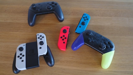Joy-Cons in a holder (bottom left), loose Joy-Cons (centre) and two Pro controllers (top left and bottom right).