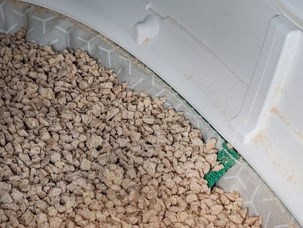 The shelf with the litter is attached under an edge.