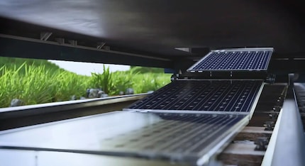 The solar modules are automatically rolled out onto the track bed by the train.