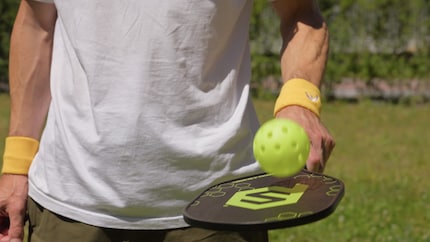 The pickleball part of the game: a wooden bat and a plastic ball.