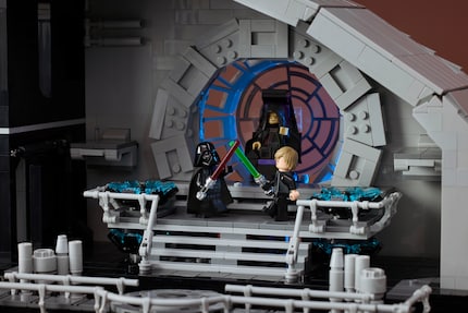 Luke and Vader meet in the throne room, watched by the Emperor.