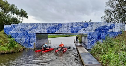 Die Brücke ist zugleich ein Denkmal, das Mosaik besteht aus Portraits von Fahrerinnen und Fahrern der Elfstedentocht.
